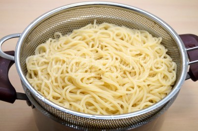 Откинуть спагетти на дуршлаг и дать воде полностью стечь.