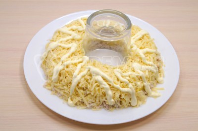 150 грамм твердого сыра натереть на терке и выложить слоем на ананасы. Смазать майонезом.