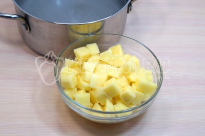 В кастрюлю влить 3 литра воды, добавить 3 картофелины нарезанные кубиками. Варить после закипания 3-4 минуты.