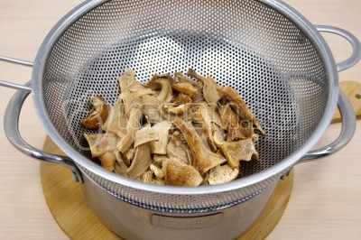 Сушеные белые грибы процедить так, чтобы отвар от грибов остался в миске.