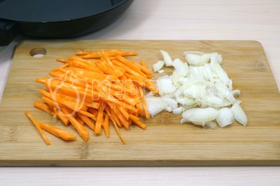 Чтобы приготовить плов с курицей на сковороде, нужно луковицу не крупно нарезать, морковь нарезать соломкой.