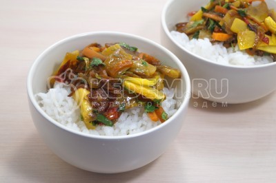 В глубокие тарелки выложить рис, добавить тыкву с овощами сверху.
