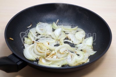 Добавить в сковороду полукольцами нарезанную луковицу и обжарить 1 минуту, помешивая.