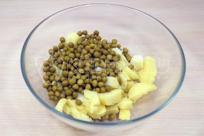 Картофель нарезать кубками в миску и добавить 100 грамм консервированного горошка.