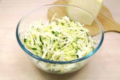 Заправить салат из свежей капусты с огурцом 2 столовыми ложками растительного масла. Перемешать и дать настояться 10 минут.
