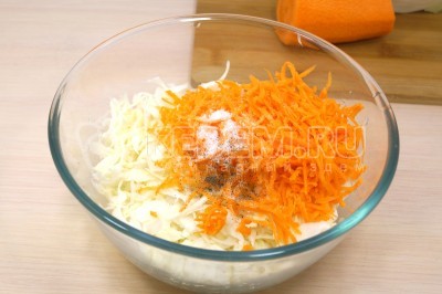 В миску к капусте с морковью добавить 1/4 чайной ложки соли, 1/2 чайной ложки сахара и черный молотый перец по вкусу.
