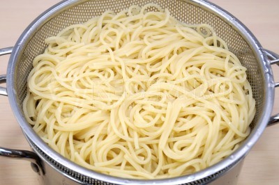 Спагетти откинуть на дуршлаг и дать воде полностью стечь.