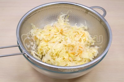 Чтобы приготовить вареники с квашеной капустой, нужно 250 грамм квашеной капусты откинуть на дуршлаг и слить рассол.