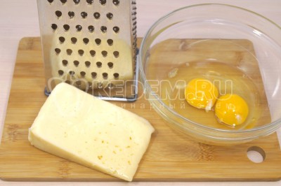 В миске взбить 2 яйца. 200 грамм твердого сыра натереть на терке.