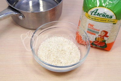 Чтобы приготовить запеченные фаршированные перцы, нужно в глубокую миску отмерить 100 грамм круглозерного риса.