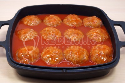 Влить соус из томатной пасты в форму с тефтелями.