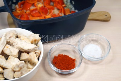 Добавить в сотейник к обжаренным овощам 1 столовую ложку паприки, 1/2 чайной ложки соли и обжаренное куриное филе.