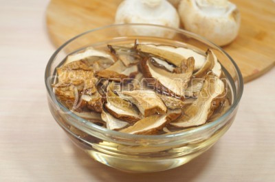 Чтобы приготовить суп с перловкой и грибами, нужно 50 грамм сушеных белых грибов замочить в 300 миллилитрах воды.