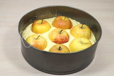 Выложить яблоки в тесто и немного углубить их.