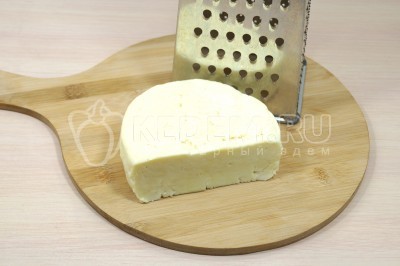 Приготовить начинку для вареников с сыром. Для этого 300 грамм адыгейского сыра натереть на крупной терке в миску.