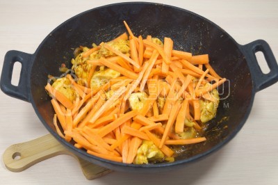 Добавить в казан морковь и готовить 3-4 минуты.
