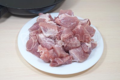 Чтобы приготовить жаркое в горшочках в духовке, нужно 400 грамм мякоти свинины нарезать небольшими кусочками.