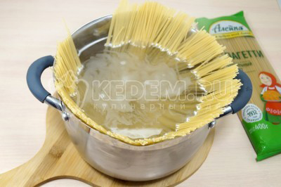 Отмерить 200 грамм спагетти и опустить спагетти в кипящую воду.