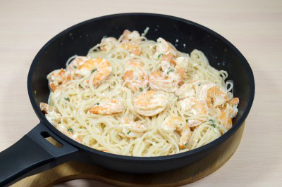Добавить горячие спагетти в сковороду и перемешать, готовить 1-2 минуты.