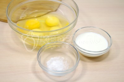 Чтобы приготовить омлет с сосисками на сковороде нужно в миске смешать 4 яйца, 100 миллилитров молока и 1/4 чайной ложки соли.