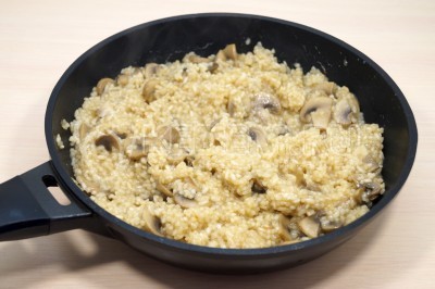 Добавить еще часть бульона и снова помешивая довести до вязкого состояния риса. Готовить 12-15 минут помешивая, добавляя грибной бульон при необходимости.