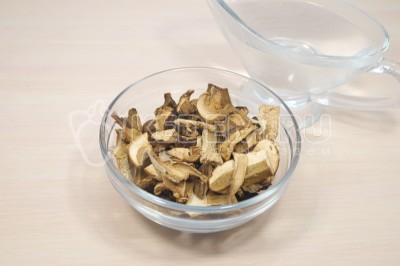 Чтобы приготовить тушеную картошку с сушеными грибами на сковороде нужно 100 грамм сушеных белых грибов залить 500 миллилитрами воды комнатной температуры и оставить на 15-20 минут.