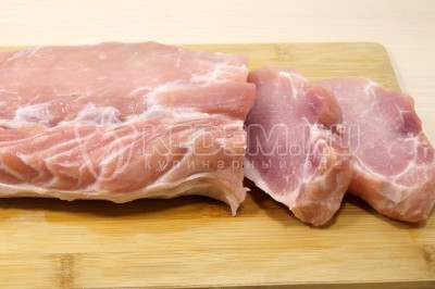 Чтобы приготовить отбивные с луком и сыром в духовке нужно свиную вырезку нарезать ломтиками.