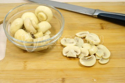 Чтобы приготовить салат с маринованными шампиньонами, кукурузой и сыром нужно 200 грамм маринованных шампиньонов нарезать ломтиками.