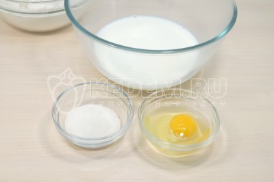 В большой миске смешать 300 миллилитров теплого молока, 2 столовые ложки сахара и 1 яйцо.