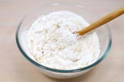 Добавить кипяток с маслом и солью в муку и осторожно замесить тесто лопаткой. Замешивать тесто для лаваша нужно именно лопаткой, так как тесто горячее.