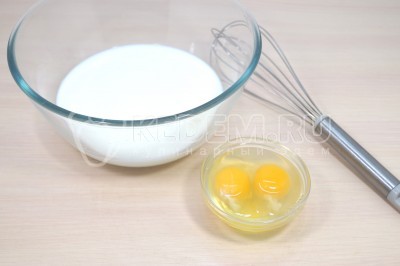 Чтобы приготовить блинчики с творожной начинкой нужно в миску влить 300 миллилитров молока. Добавить 2 яйца. Взбить венчиком.