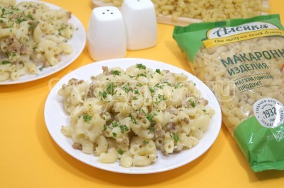 Макароны с фаршем и соусом бешамель на столе.