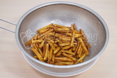 Снять картофель фри и удалить лишнее масло. Промокнуть бумажными полотенцами.