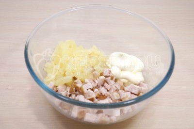 В большой миске смешать тертый сыр, кусочки куриного филе, консервированные ананасы и 2 столовые ложки майонеза.