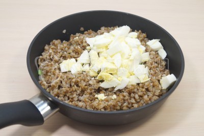 Добавить в сковороду нарезанные куриные яйца.