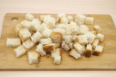 Нарезать хлеб небольшими кубиками.