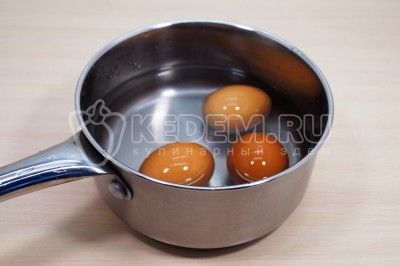 Чтобы приготовить салат с тунцом и яйцом нужно три куриных яйца отварить, остудить и очистить.