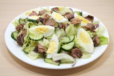 Добавить четвертинками нарезанные яйца и кусочки консервированной тунца.