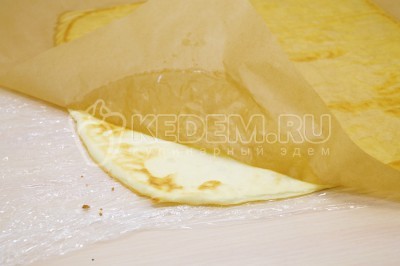 Перевернуть яичный пласт на пленку. Убрать противень. Снять пергамент.