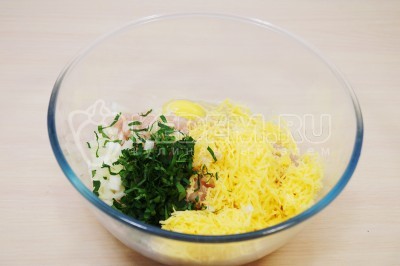 Добавить в миску к рубленому мясу тертый сыр и мелко нашинкованную зелень петрушки.