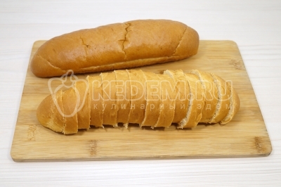 Чтобы приготовить бутерброды с помидорами и сыром с чесноком, нужно батон нарезать тонкими ломтиками.