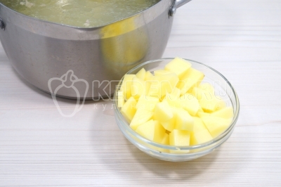 Добавить в кастрюлю с бульоном кубиками нарезанные 2 картофелины.