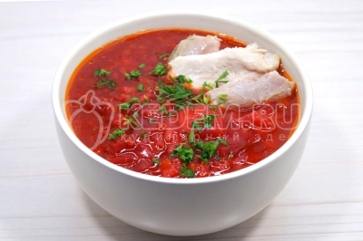 Разлить свекольник по тарелкам. Добавить мясо без косточек и мелко нарубленную зелень петрушки.