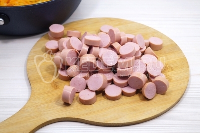 Нарезать 200 грамм сосисок кружочками.