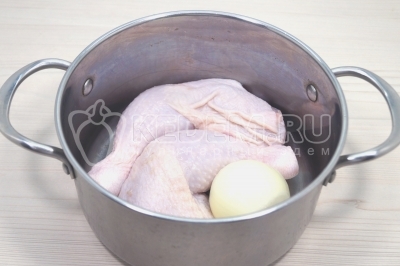 Чтобы приготовить домашнюю лапшу с курицей, нужно в кастрюлю выложить 2 куриных окорочка или половину небольшой курицы и 1 луковицу. Добавить 2,5-3 литра воды и варить до закипания.