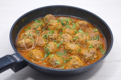 Снять сковороду с огня и посыпать фрикадельки измельченной зеленью петрушки.