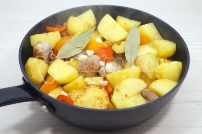 Добавить 2 лавровых листа и чеснок. Готовить еще 5-7 минут.