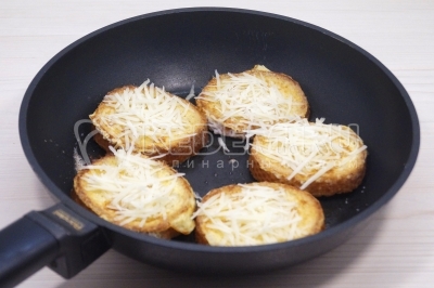 Перевернуть и сразу посыпать тертым сыром. Готовить еще 1-2 минуты, гренки поджарятся, а сыр расплавится.