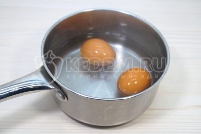 Чтобы приготовить классический салат из крабовых палочек с огурцом, нужно 2 яйца отварить, остудить и очистить.