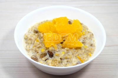 Разложить кашу по тарелкам и украсить кусочками апельсина.